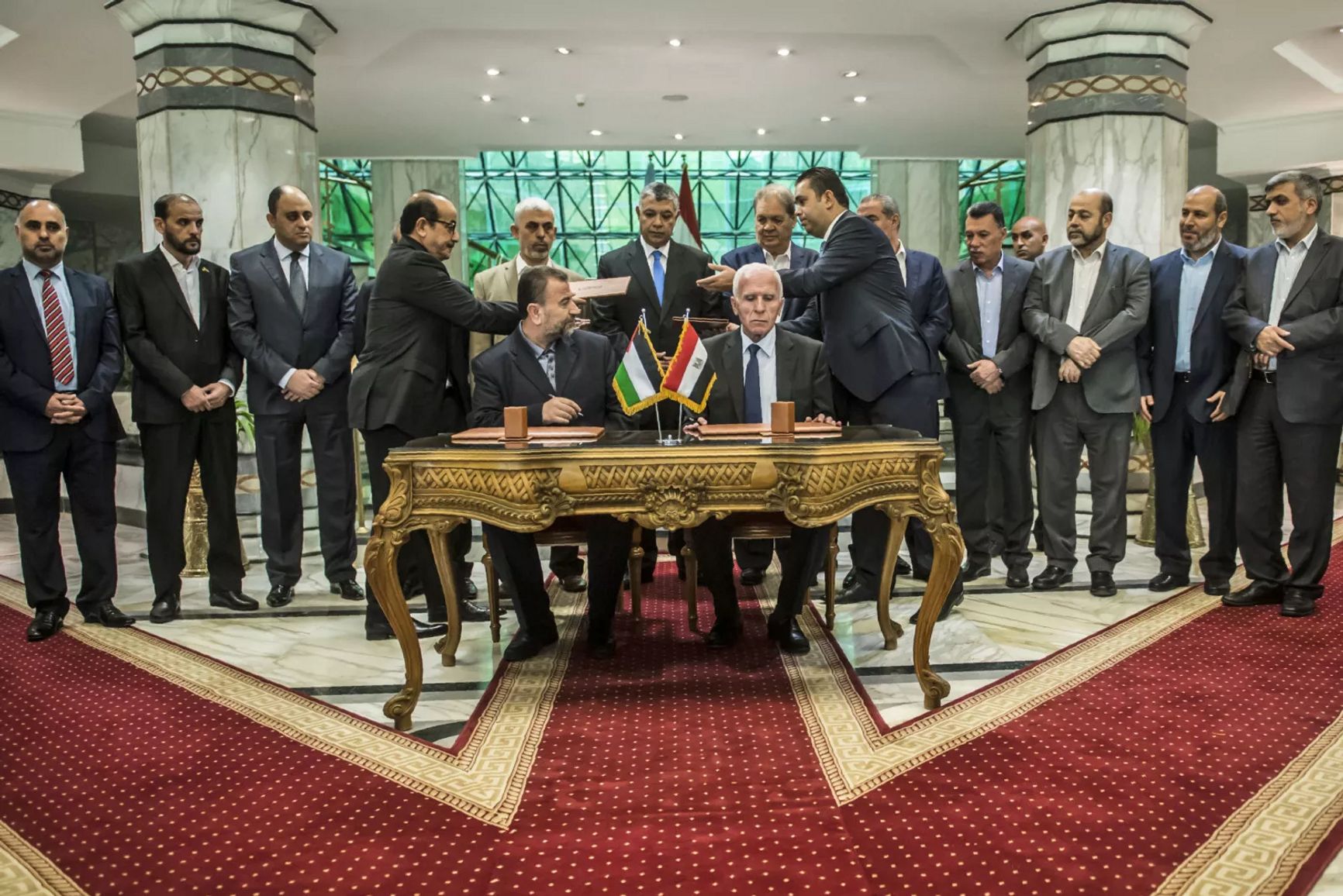 Новый заместитель лидера ХАМАС Салах аль-Арури (сидит слева) и Аззам аль-Ахмад из ФАТХ (сидит справа) подписывают соглашение о примирении, Каир, 12 октября 2017 года.